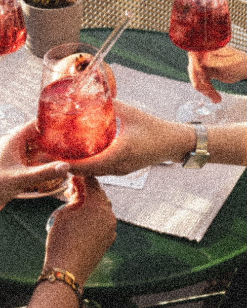 Eine Hand die einer anderen einen GRANADA NIGHTS Spritz reicht.