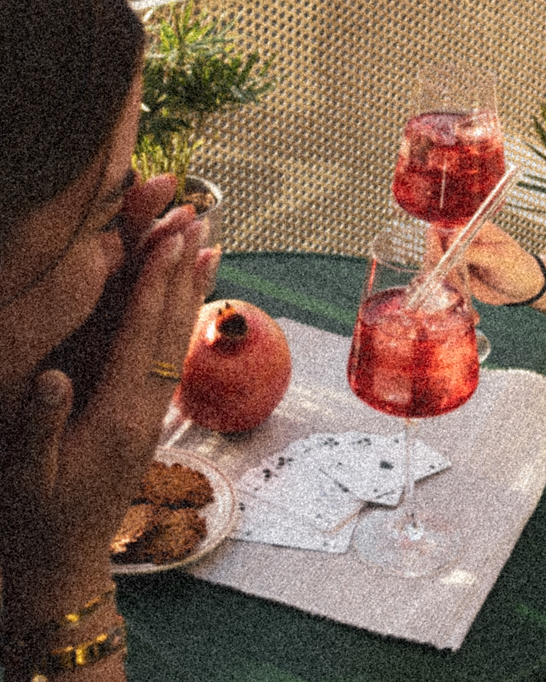 Eine Frau die lacht und im Hintergrund ein Tisch mit zwei Gläsern GRANADA NIGHTS Spritz.
