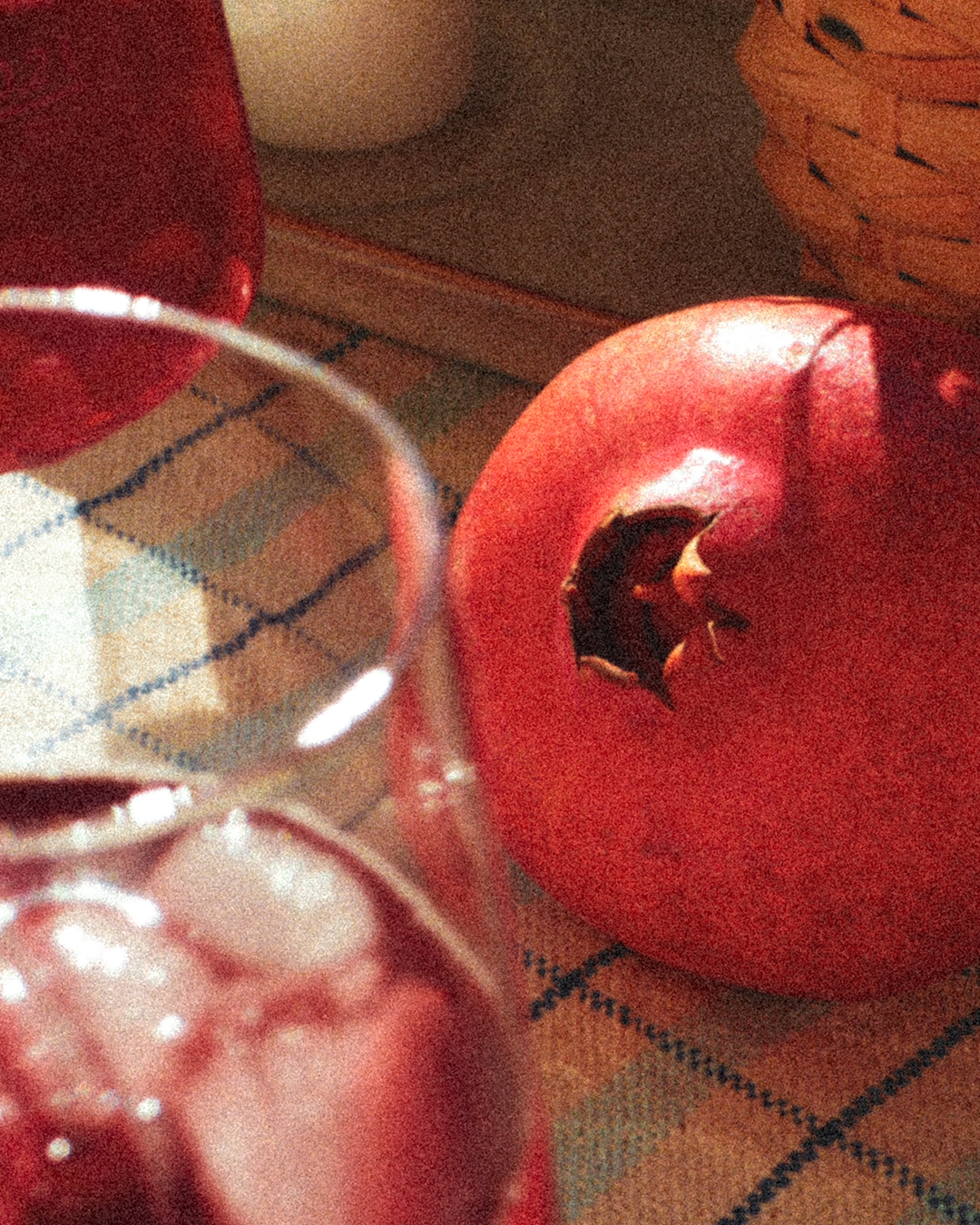 Ein Granatapfel auf einem Tisch mit zwei Gläsern GRANADA NIGHTS Spritz.