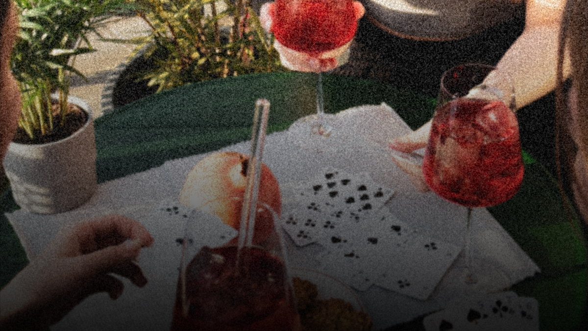 Drei Personen die Karten spielen und GRANADA NIGHTS Spritz trinken.