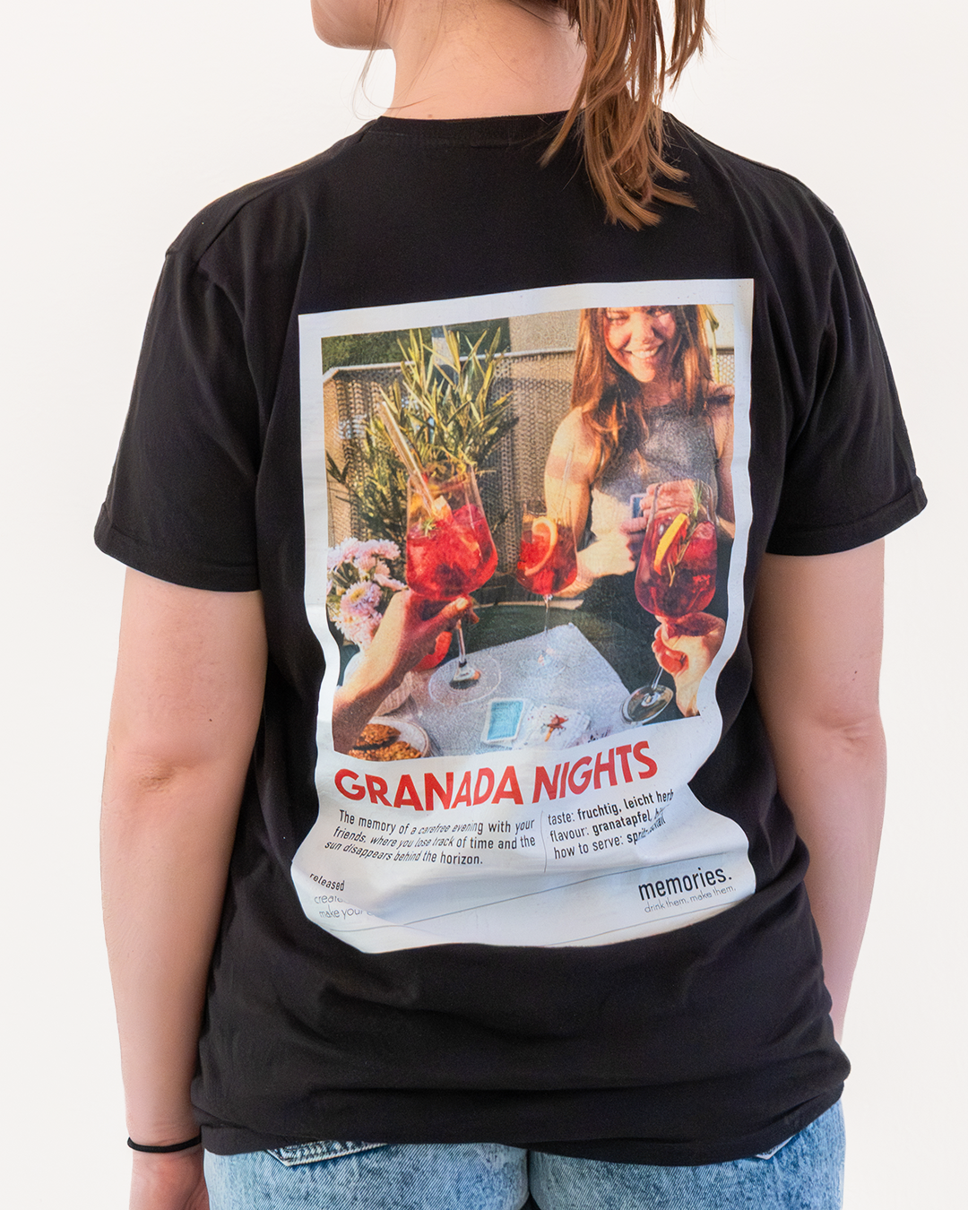 Der Rücken einer Frau mit dem T-Shirt des GRANADA NIGHTS Etiketts.