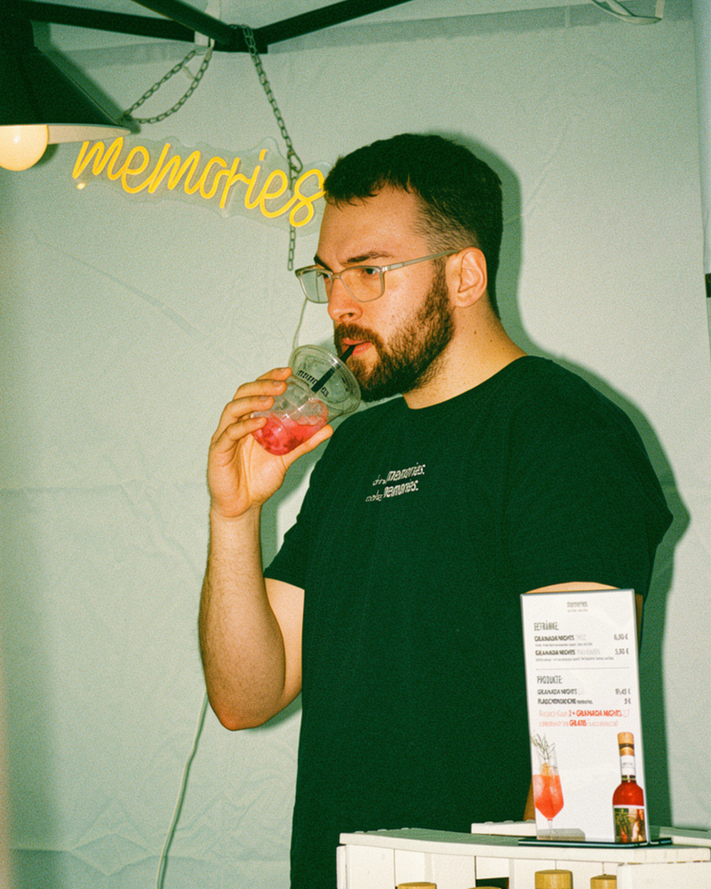 Ein Mann der aus einem Becher GRANADA NIGHTS Spritz trinkt.
