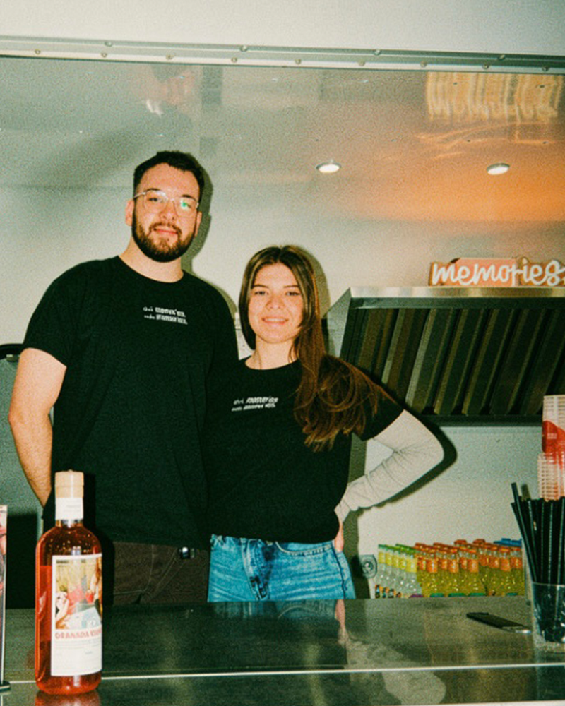 Hanna und Tim in einem Foodtruck mit einer Flasche GRANADA NIGHTS im Vordergrund