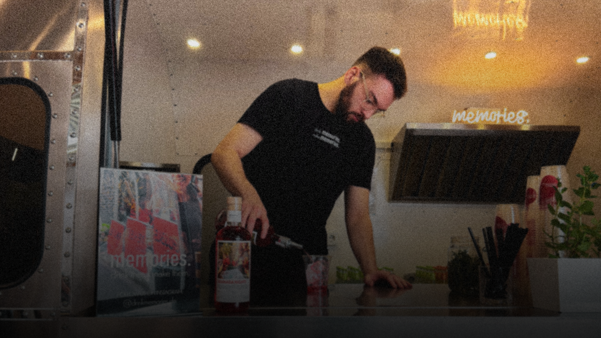 Ein Mann der in einem Food-Truck einen GRANADA NIGHTS Spritz anmischt.